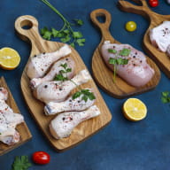 Raw chicken meat fillet, thigh, wings and legs with herbs ,spices,lemon and garlic on dark blue background. Top view